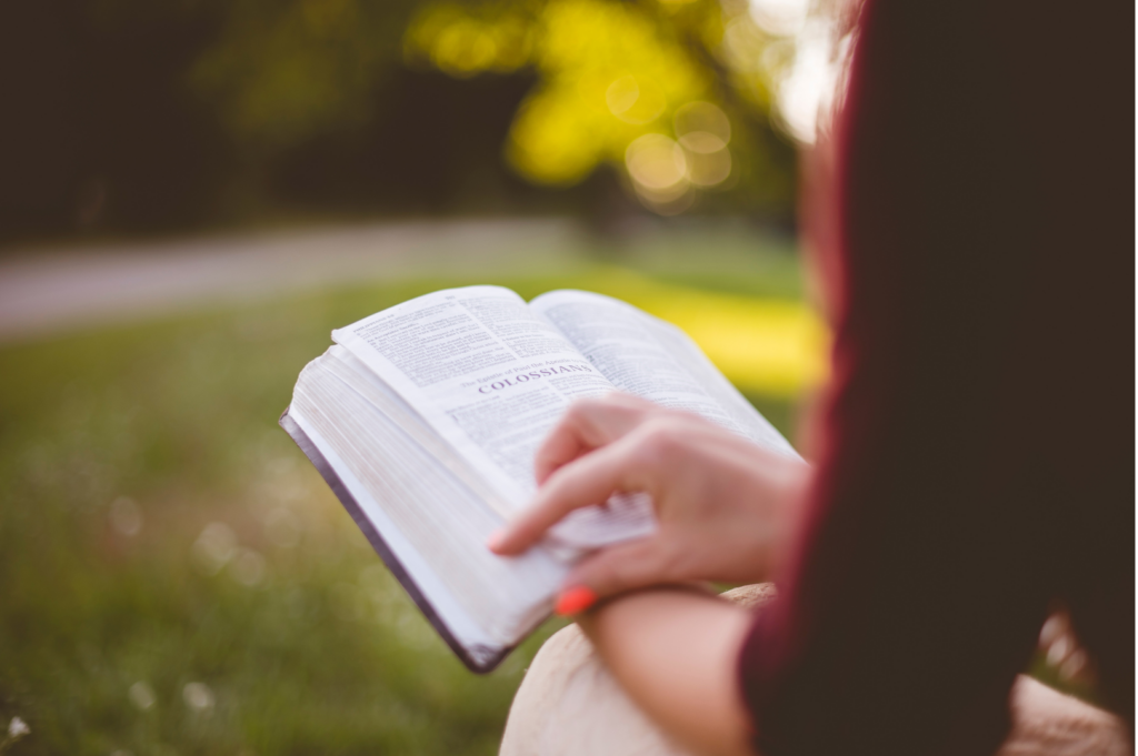 a woman reading a Bible outside