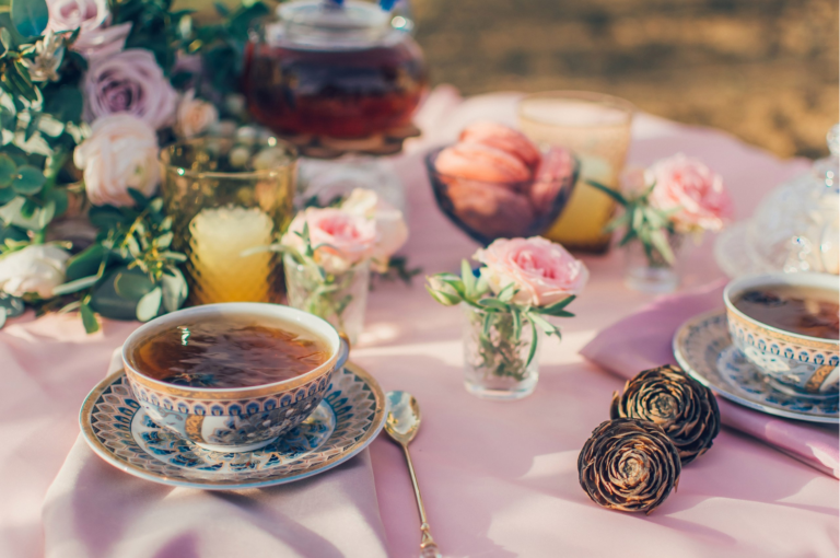 a tea party on a table with a pink table cloth