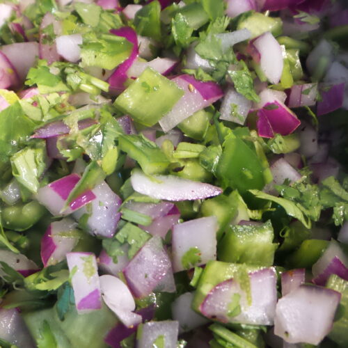 chopped onions, peppers, cilantro and lime in a bowl