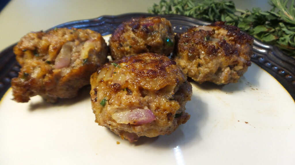 Cooked Italian meatballs sitting on a plate