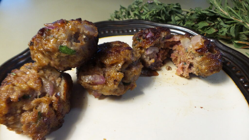 4 cooked Italian meatballs on a plate