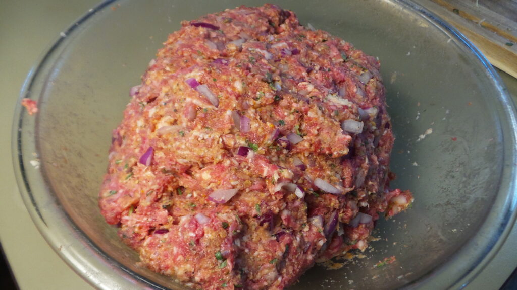 meatball ingredients mixed together in a glass bowl