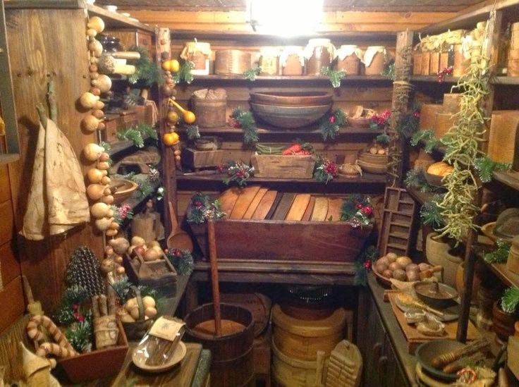 a larder with crocks, bowls, onions braids and hanging herbs