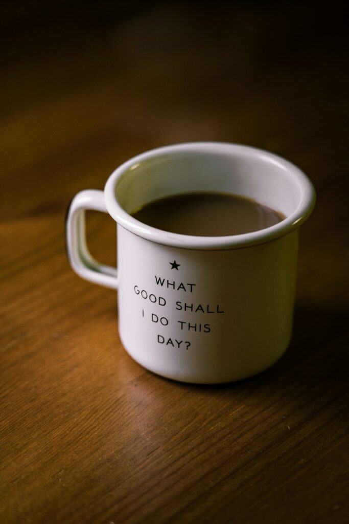a ceramic mug of coffee sitting on a brown wood table