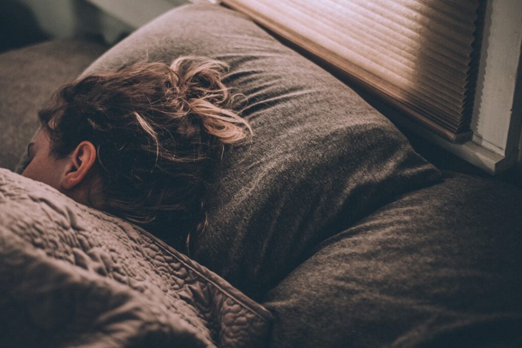 a woman sleeping on a grayish brown pillow